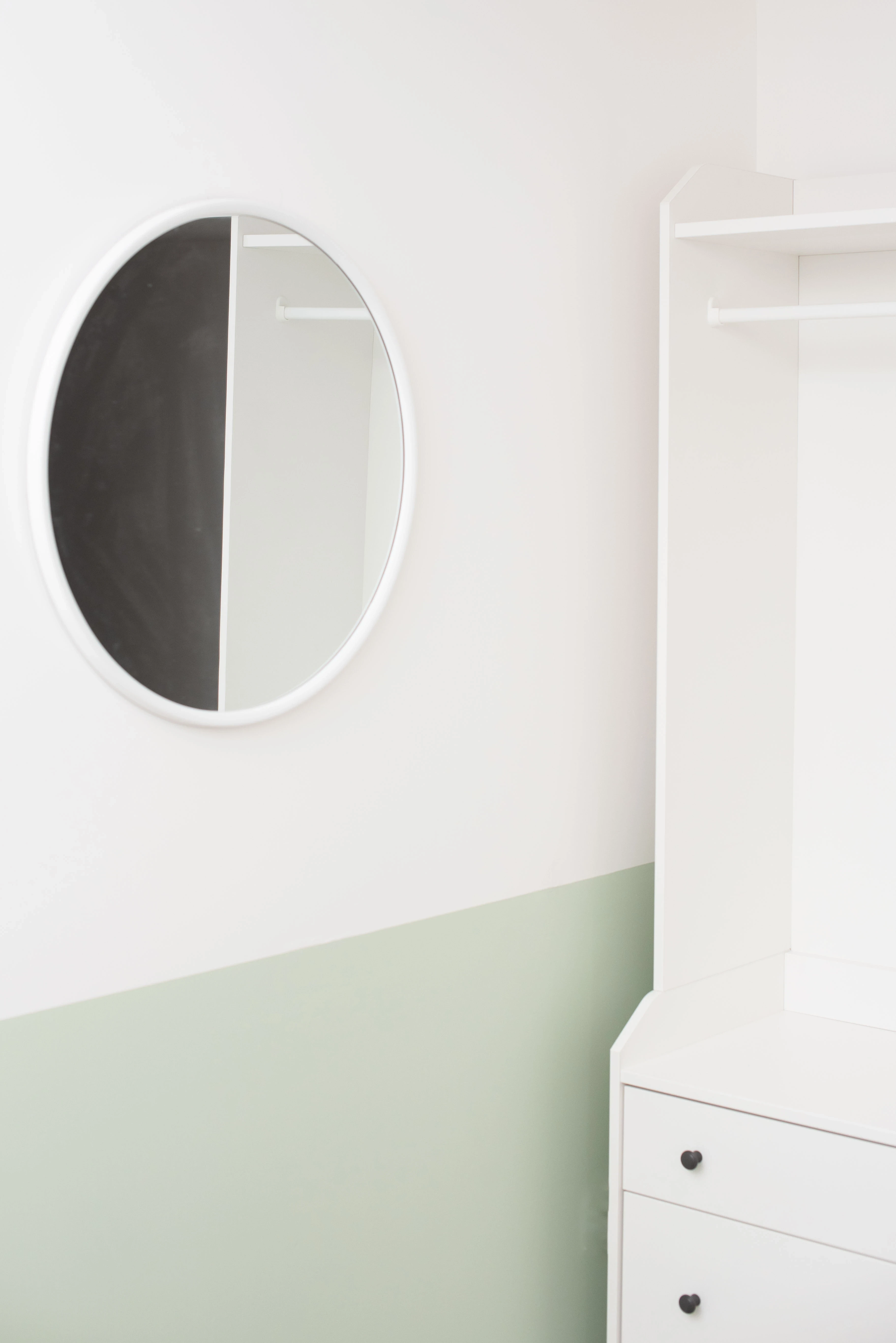 Highbury Road interior — green and white minimalist scheme with round mirror