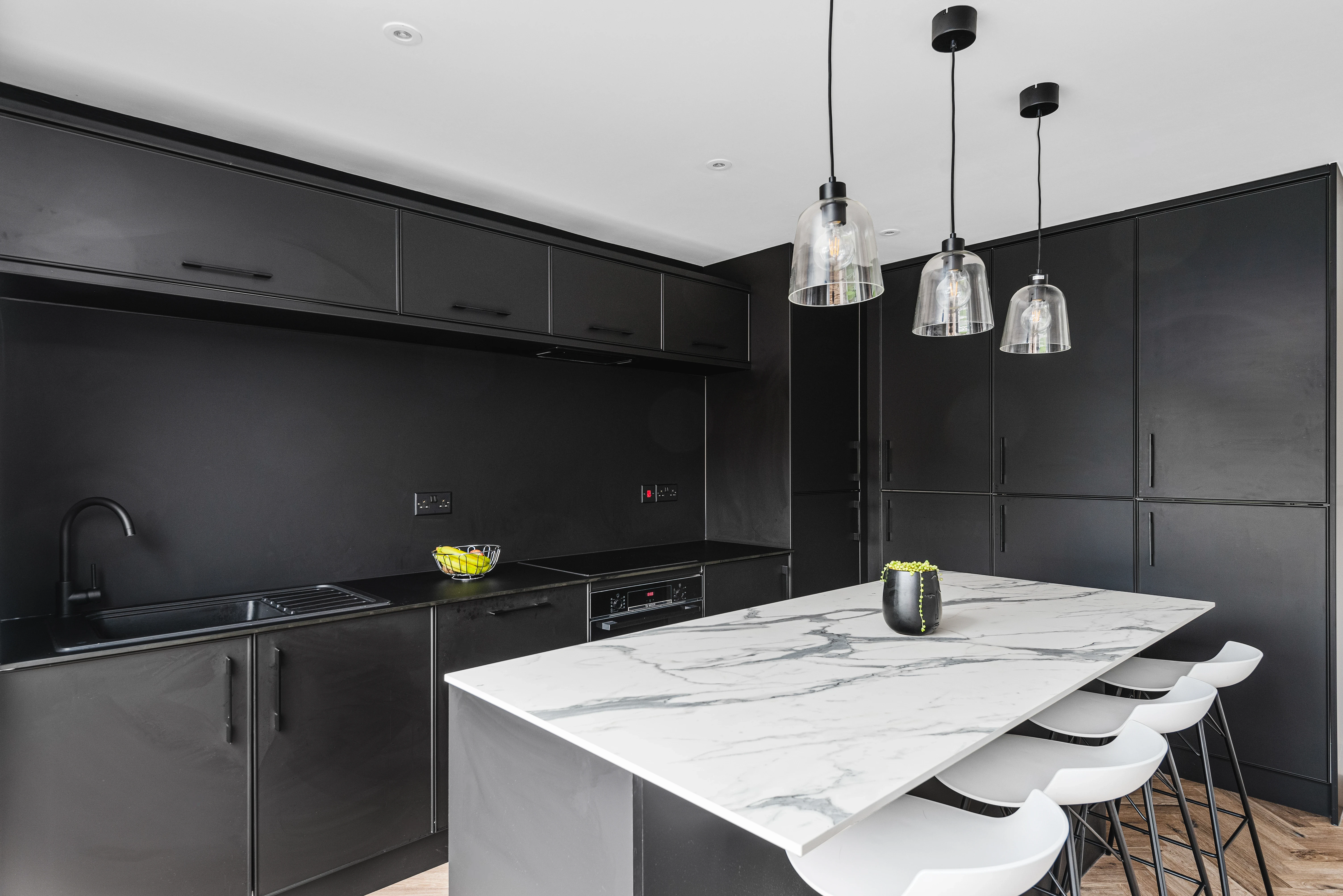 Long Road kitchen — matte black cabinetry, marble island