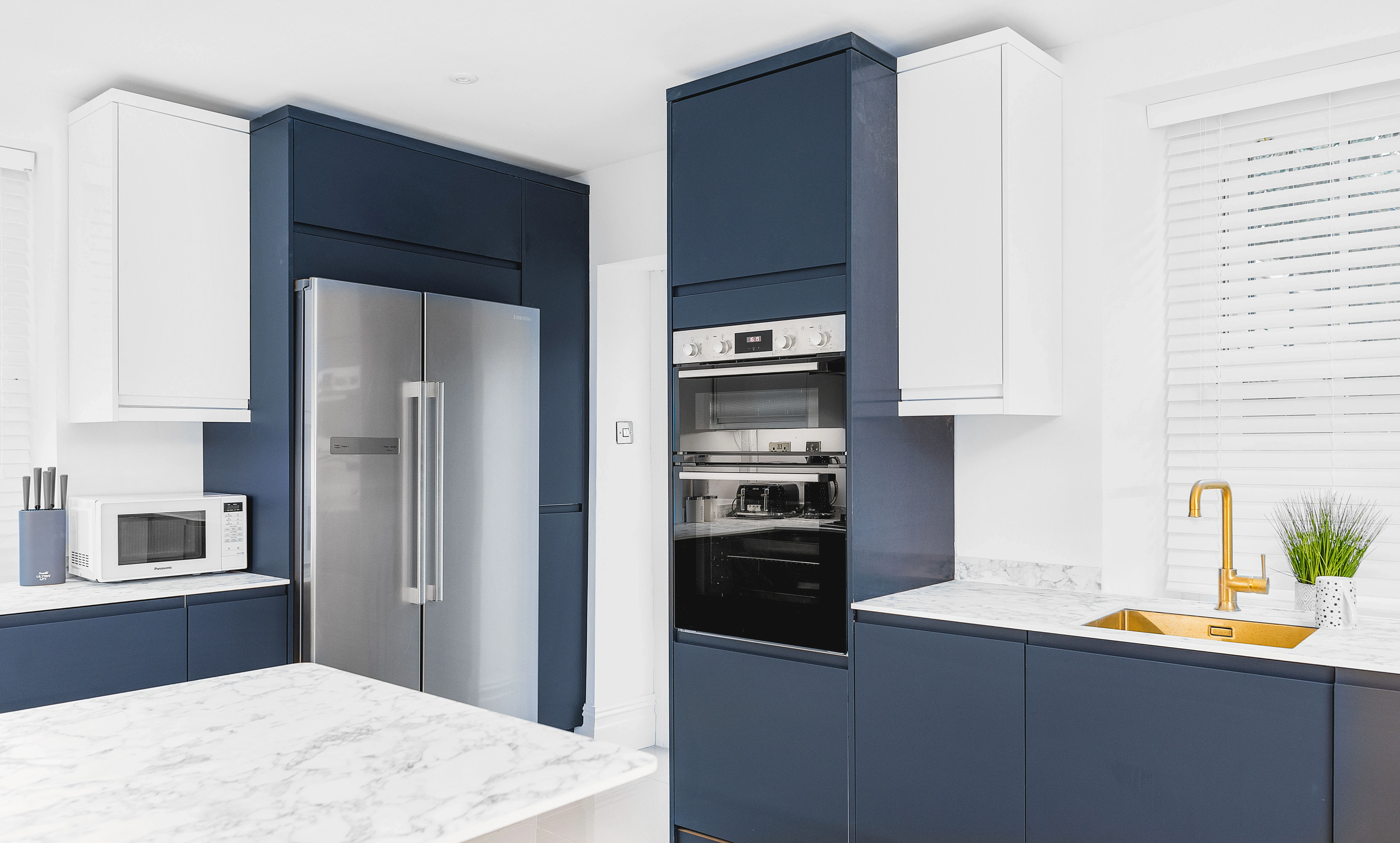 Sneyd Park kitchen — navy and white cabinetry, gold accents, marble worktop